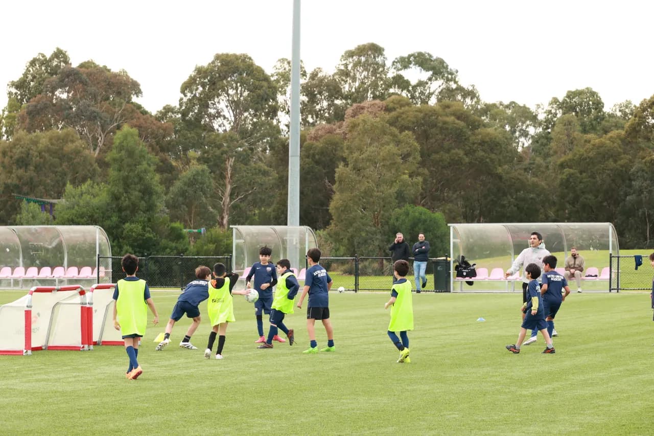 Astra United youth academy players in training bibs during a drill session on the DISC Darebin pitch